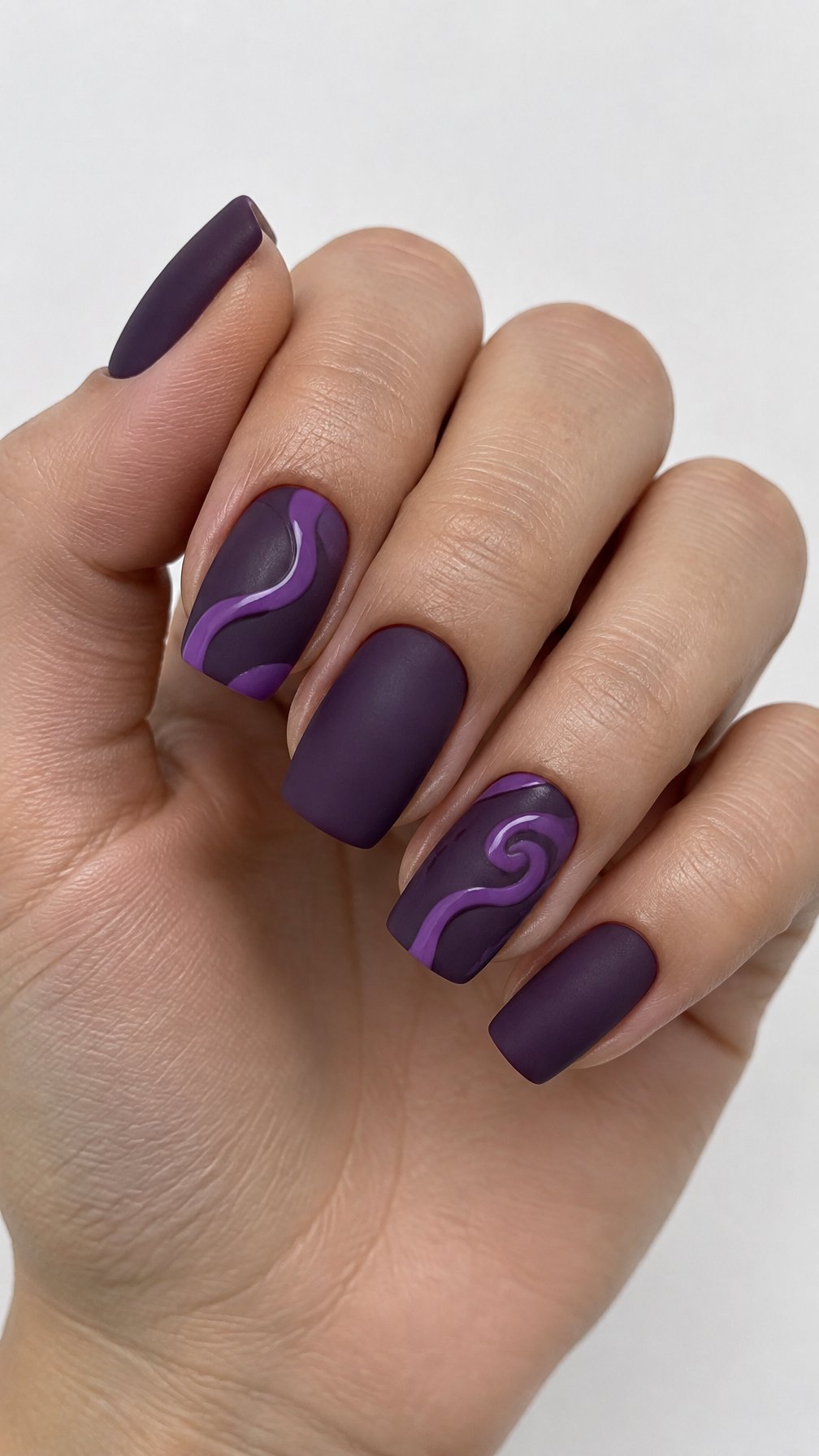 Matte grape-purple nails and glossy purple swirl designs
