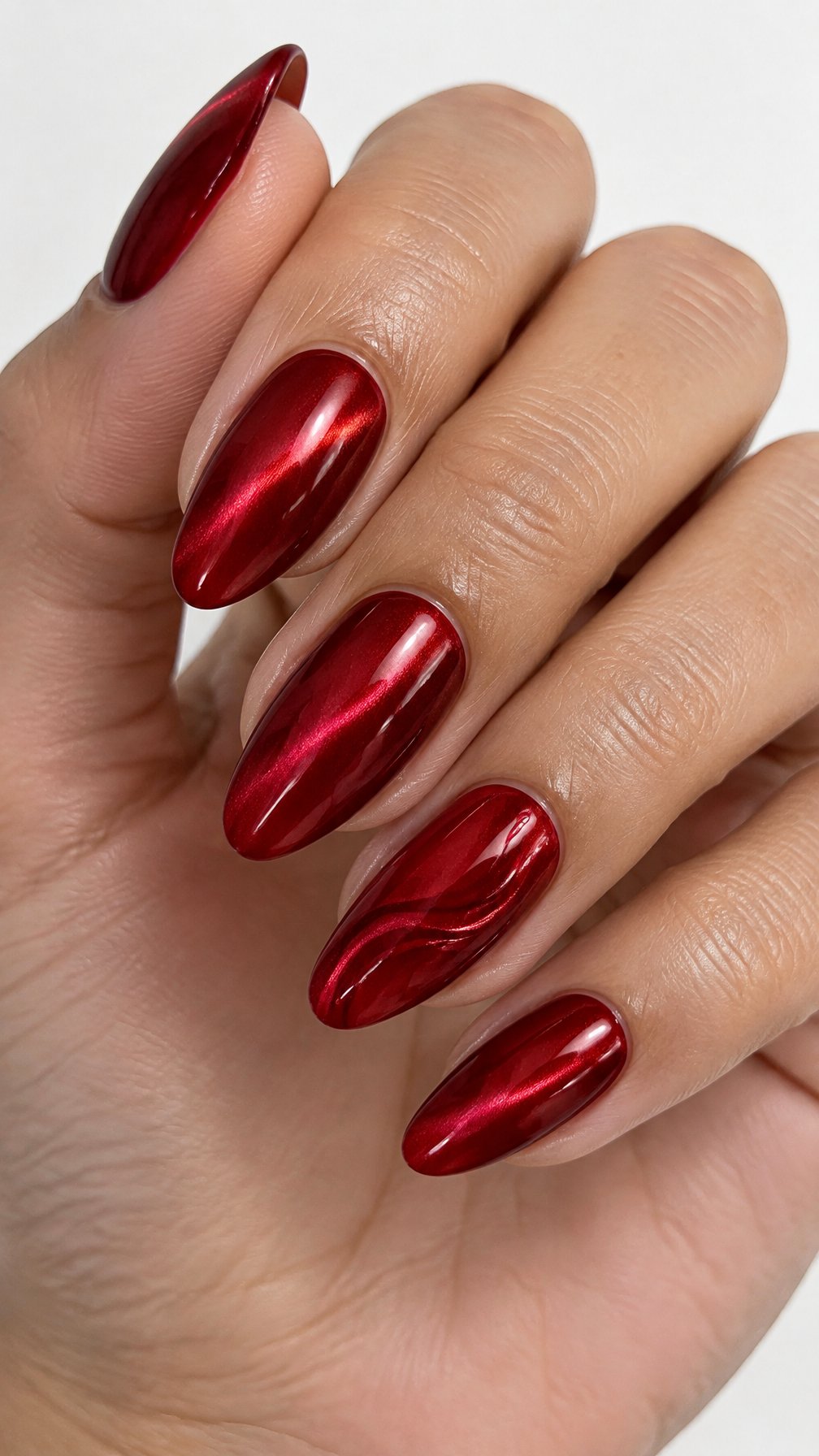 Glossy candy-apple red manicure and reflective cat-eye accents