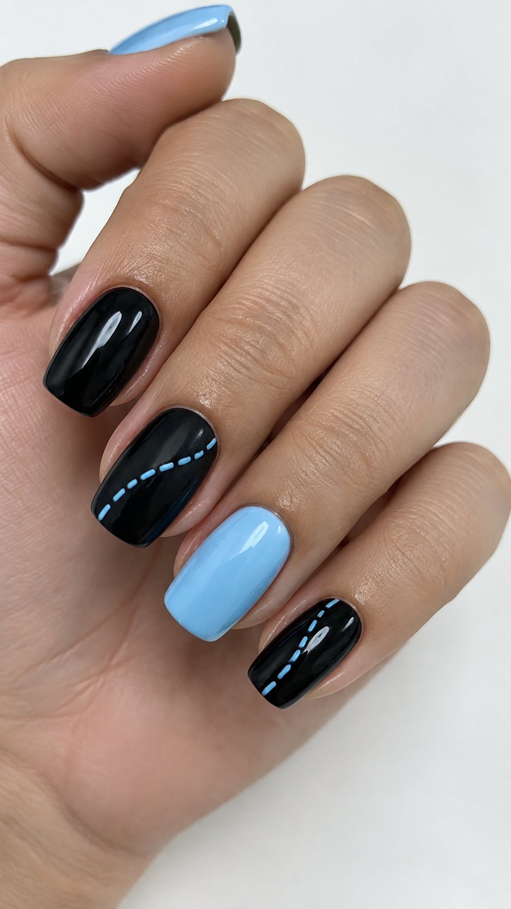 Glossy black and baby-blue manicured nails featuring delicate blue stitched lines