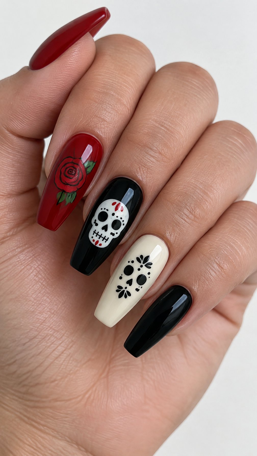 Red, black, ivory, and sugar-skull coffin-shaped nail designs