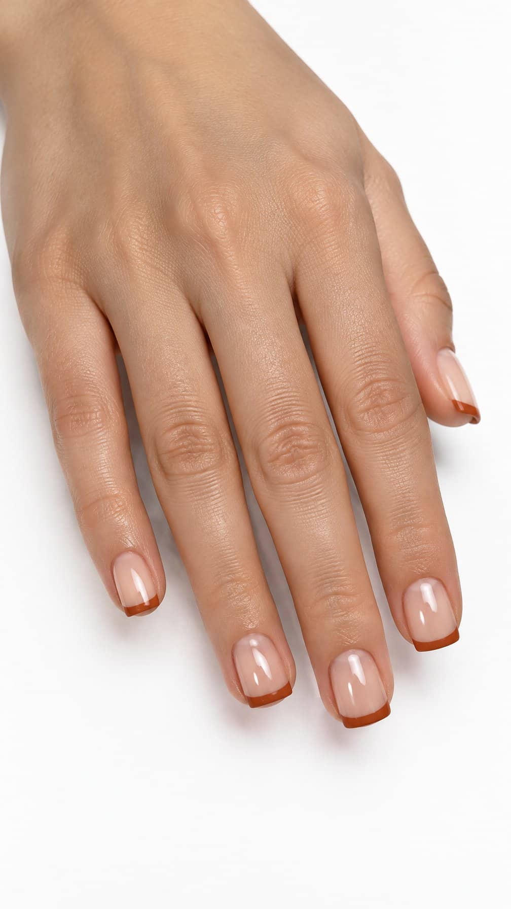 Short square nails featuring glossy terracotta French tips on a pale base