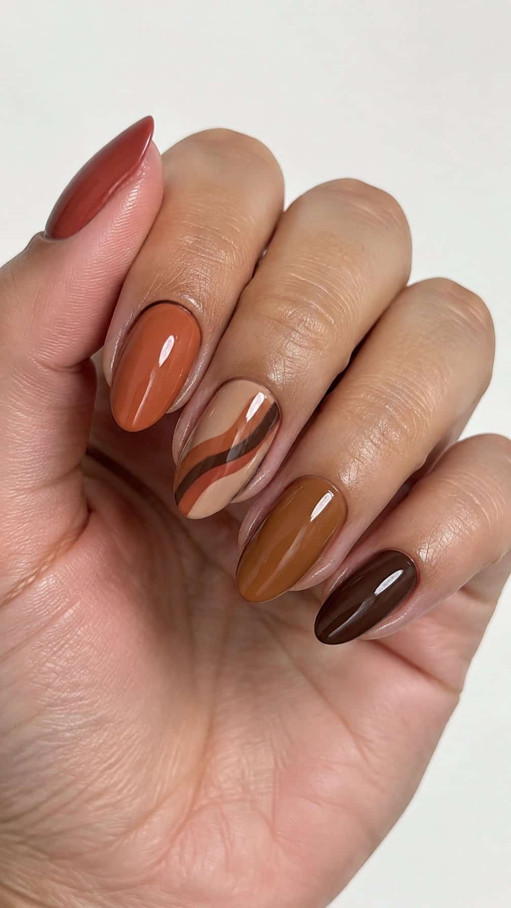 Glossy terracotta, caramel, and chocolate brown manicure