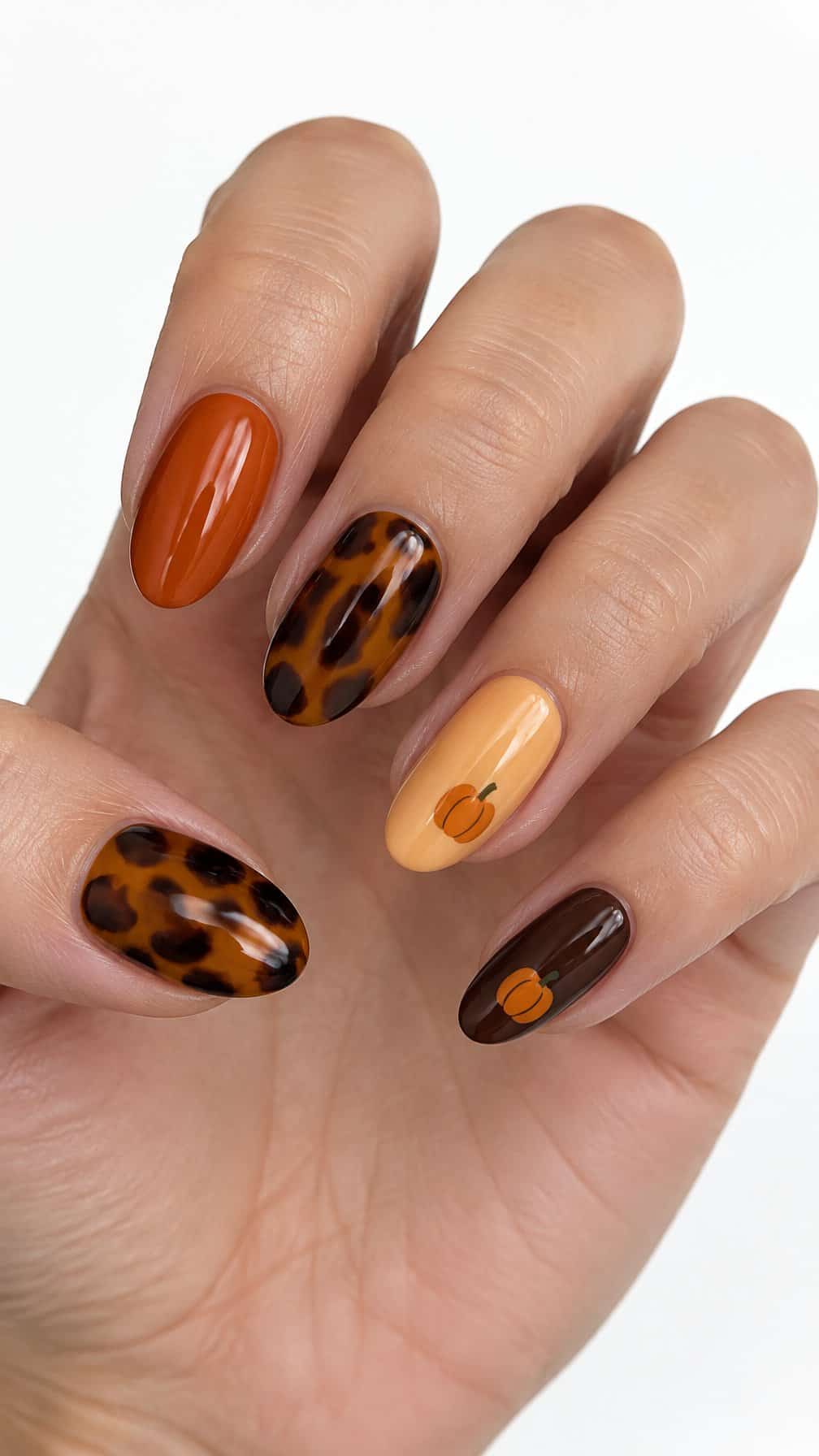 Glossy tortoiseshell and pumpkin-decorated manicure