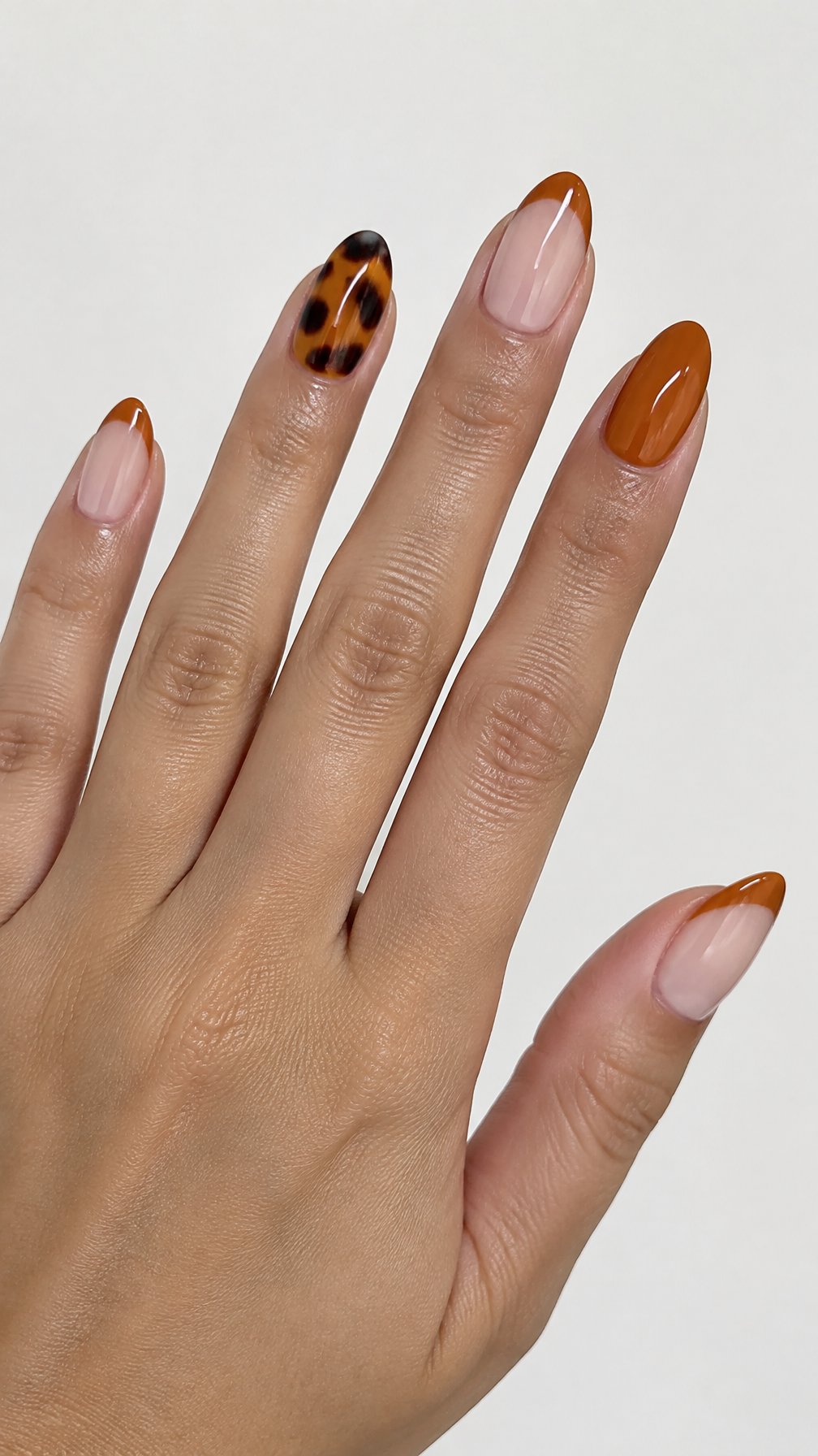 Glossy orange French tip and tortoiseshell-patterned nails