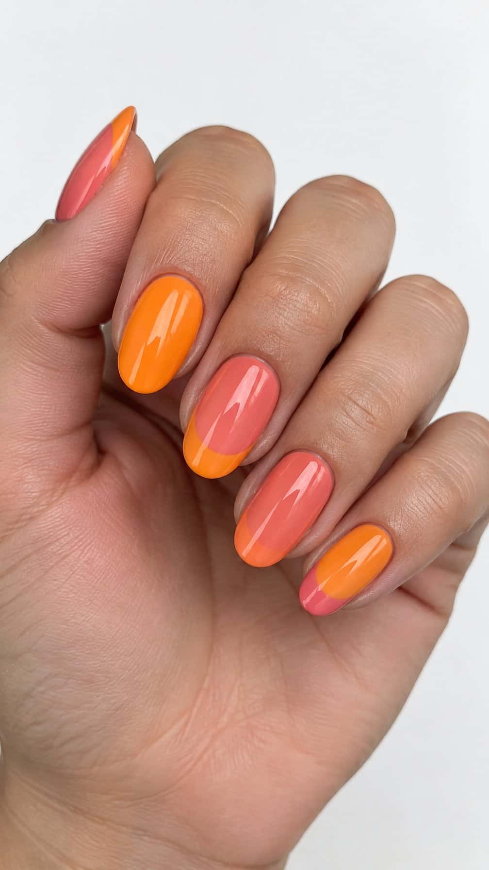 Glossy tangerine and coral French-tip nails