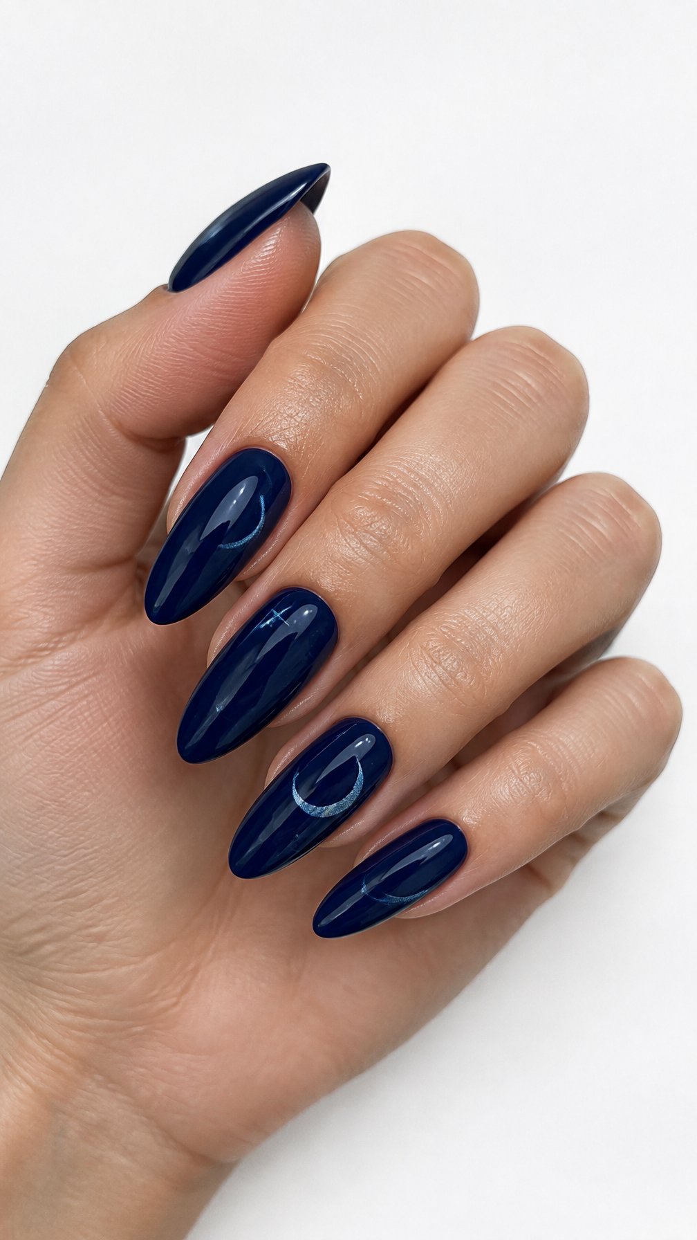 One hand with glossy midnight blue almond-shaped nails featuring delicate silver-blue details against a white background.
