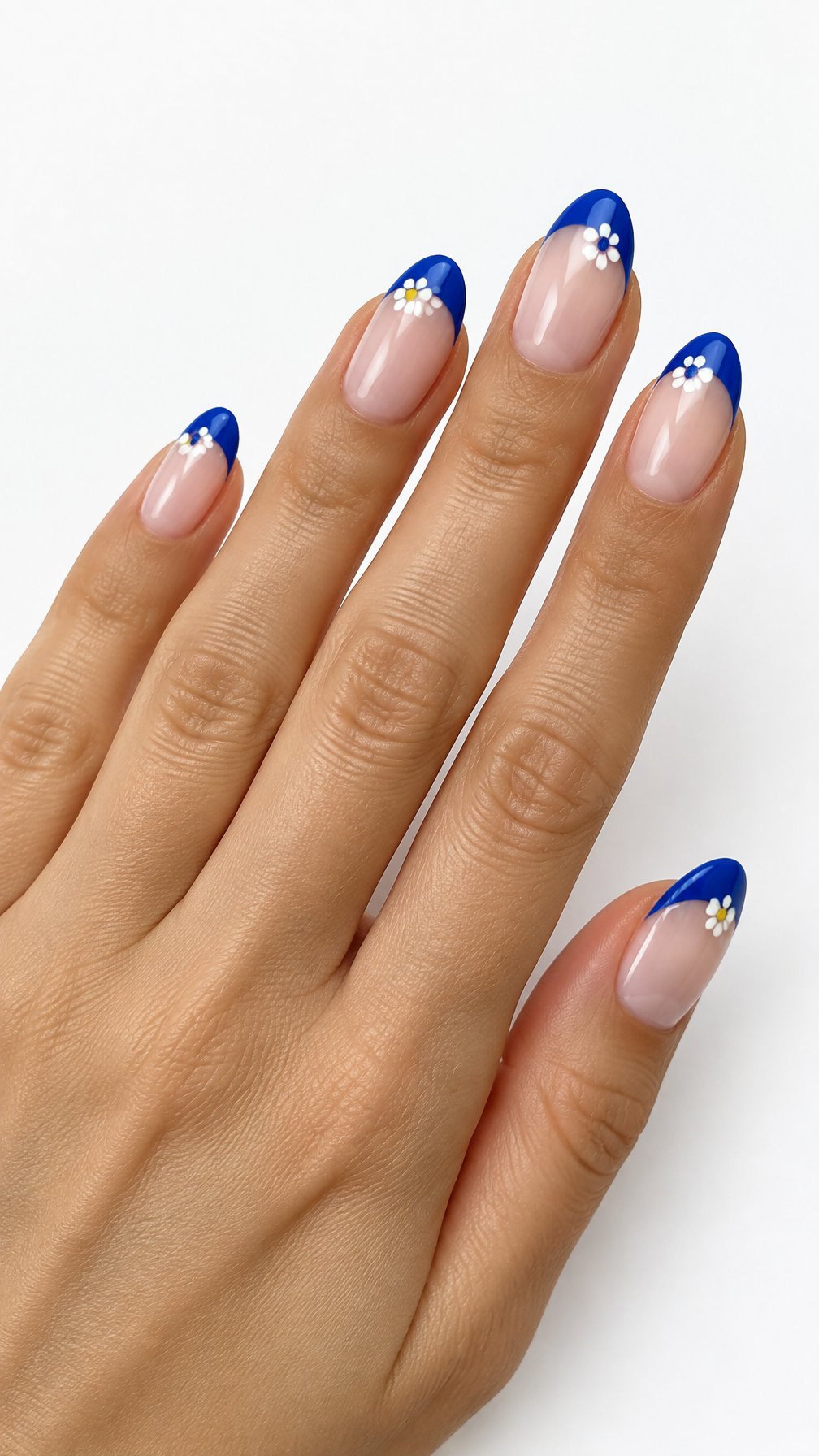 A single hand with glossy cobalt blue French-tip nails decorated with tiny white daisies against a white background.