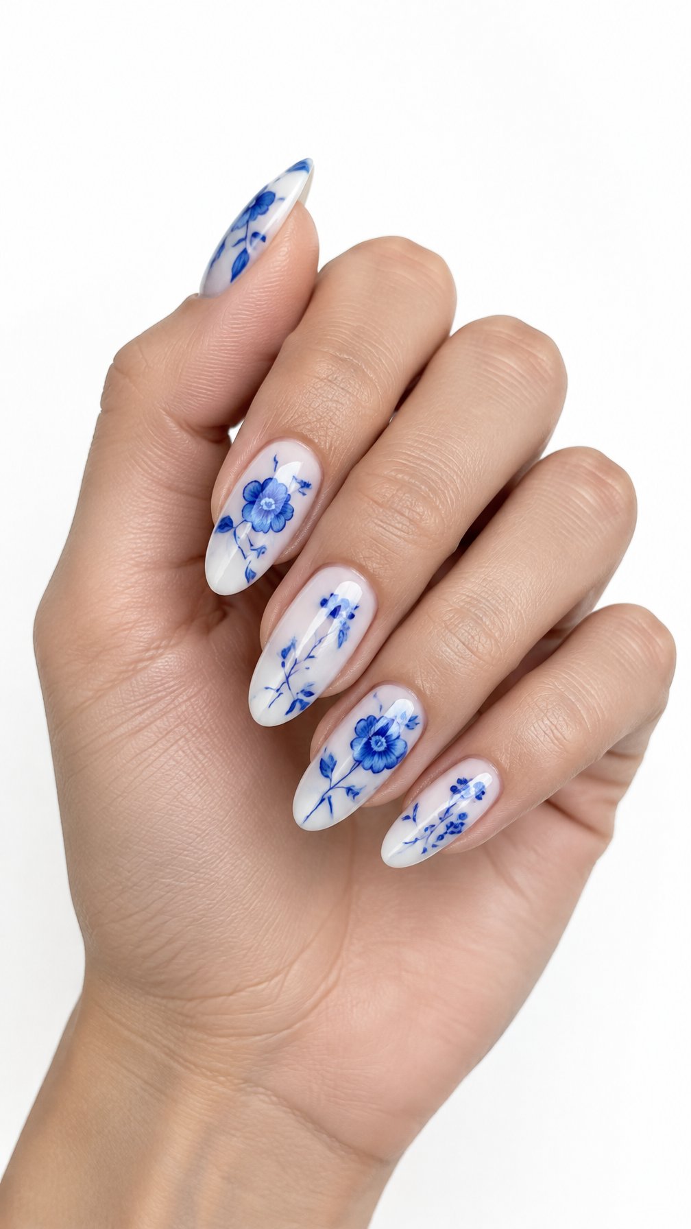 A single hand with glossy milky white nails decorated with delicate blue floral designs against a white background.