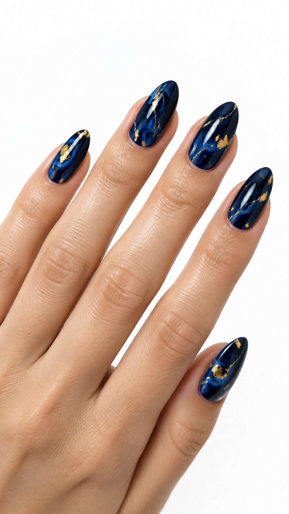 A single hand with glossy midnight blue marble nails accented with gold foil against a white background.