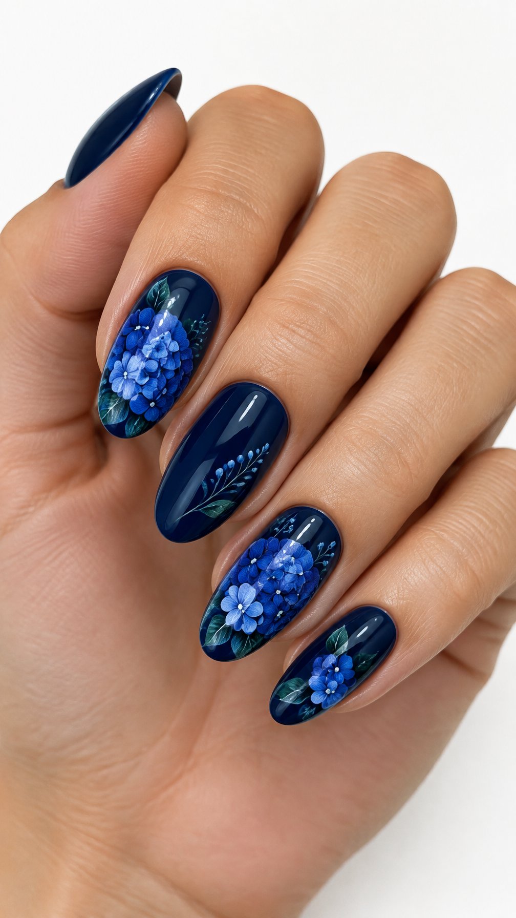 A single manicured hand with glossy navy blue hydrangea flower and leaf designs on the nails against a white background.