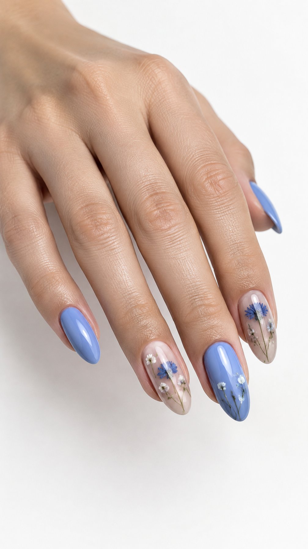 A single hand with glossy cornflower blue nails and delicate pressed-flower accents against a white background.