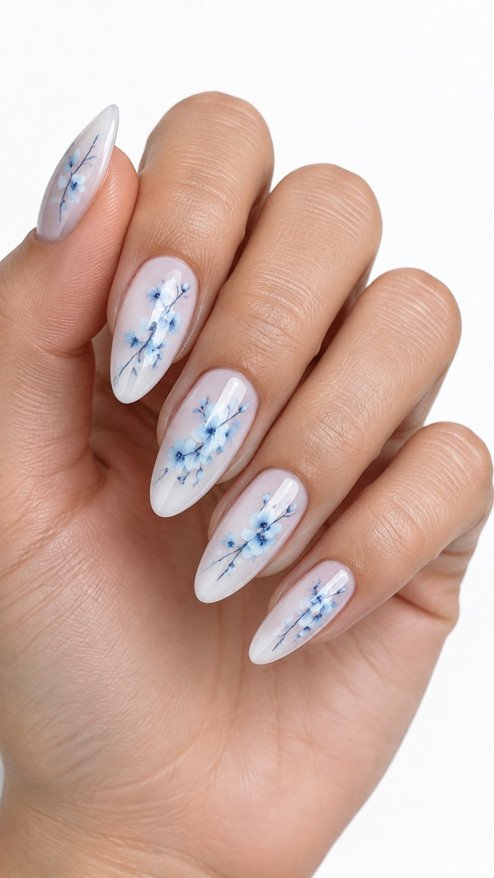 A single hand with milky-white nails decorated with delicate sky-blue cherry blossom branches on a white background.