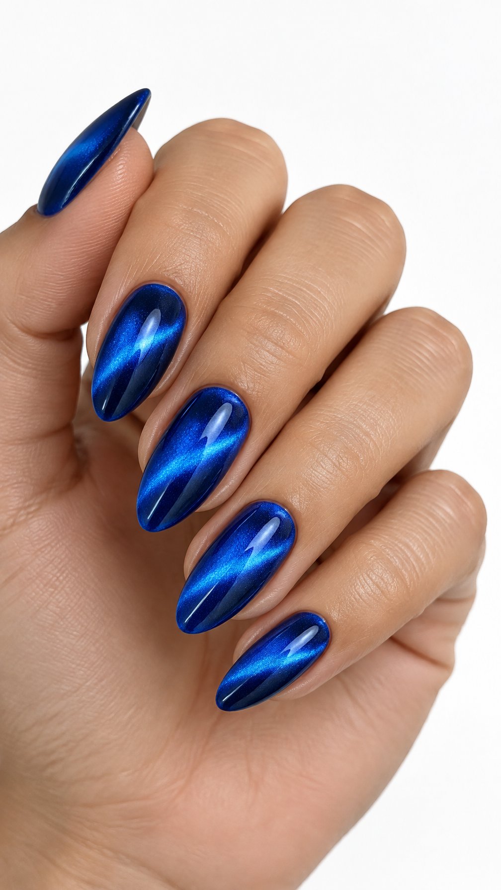 A single hand with glossy electric blue cat-eye nails rests against a white background.