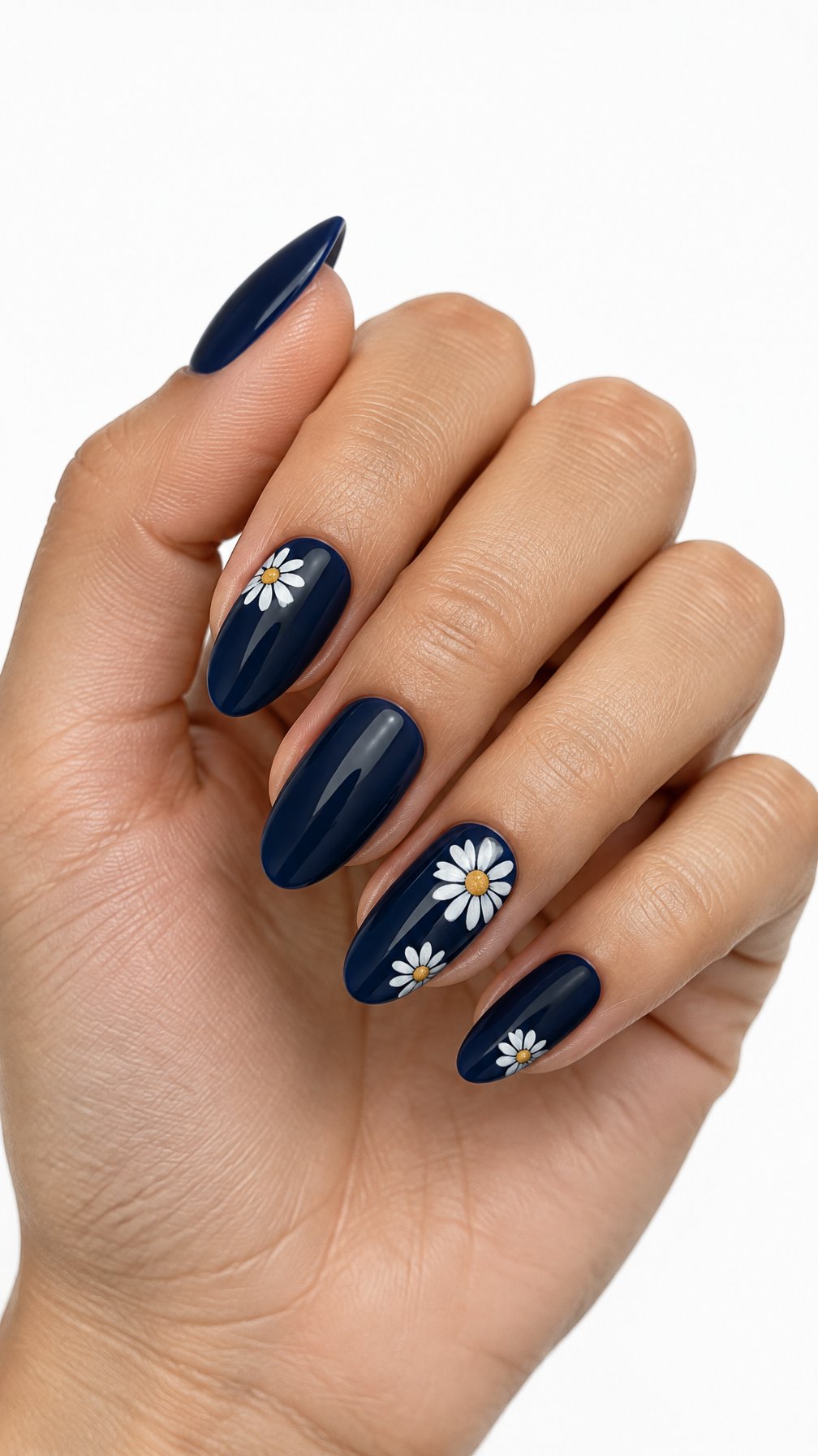A single hand with glossy midnight blue nails decorated with small white daisies on a white background.