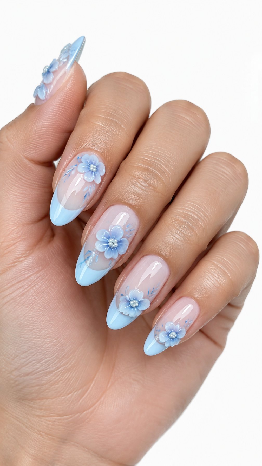 A single hand displays almond-shaped nails with icy blue tips and raised blue flower designs on a white background.