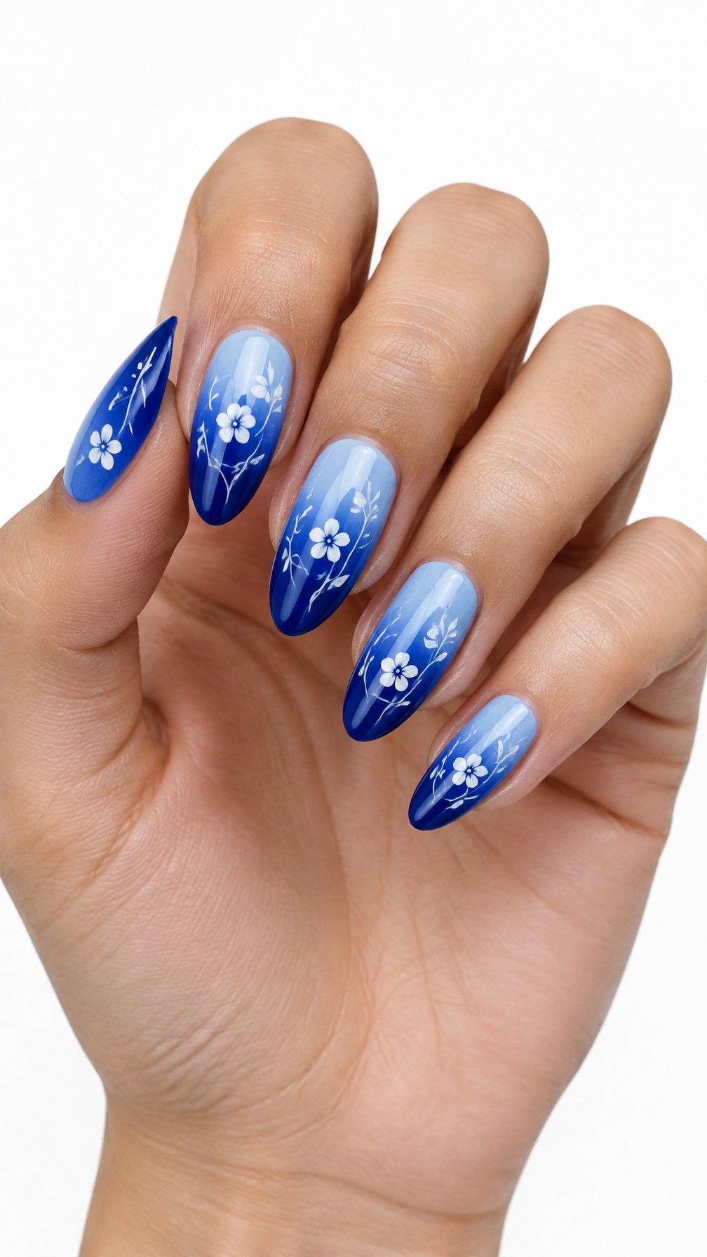 A single hand with blue ombre nails decorated with delicate white floral vines on a white background.
