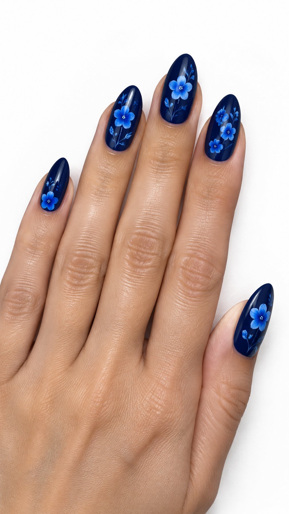 One hand with glossy navy nails decorated with delicate cobalt-blue wildflowers on a white background.