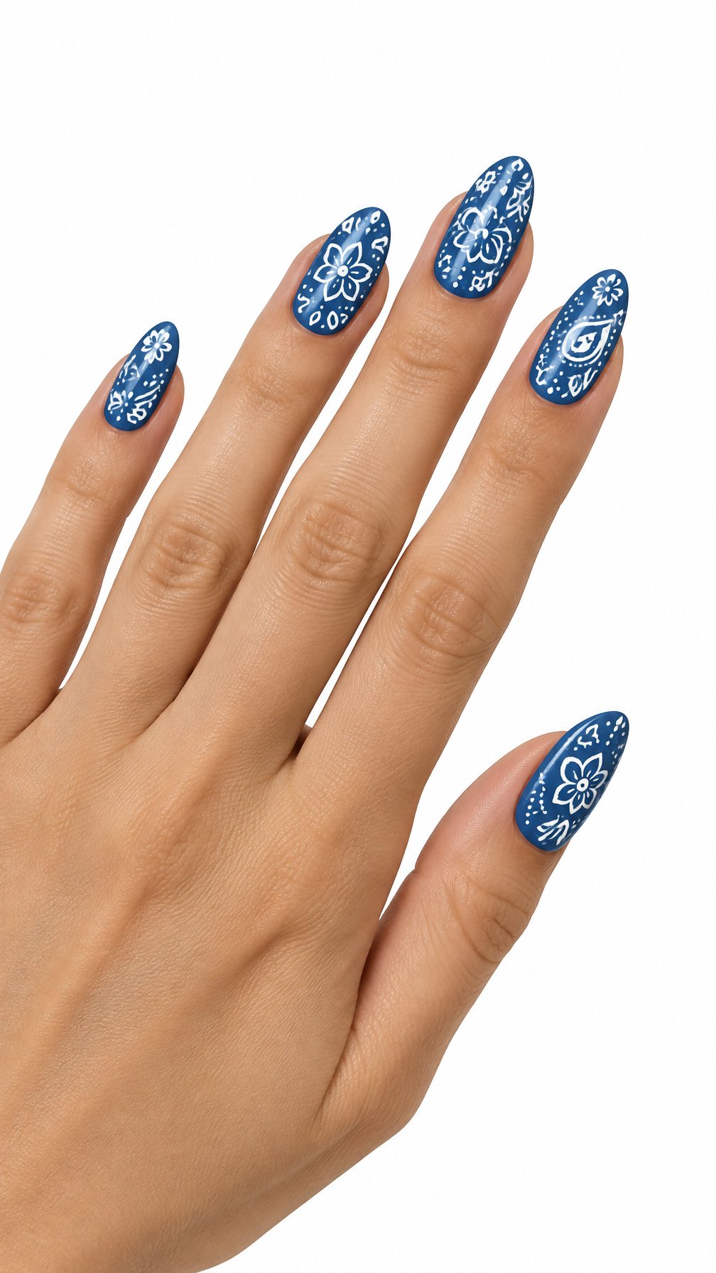 One hand with glossy denim-blue nails decorated with white floral and paisley patterns on a white background.