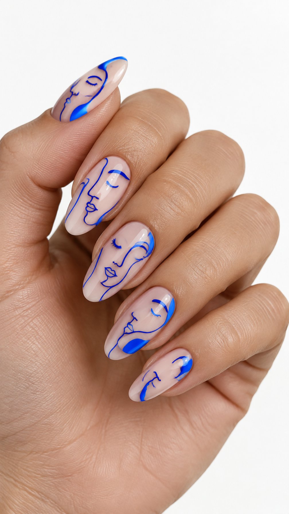 A single hand with glossy almond-shaped nails decorated with electric blue abstract face designs rests against a white background.