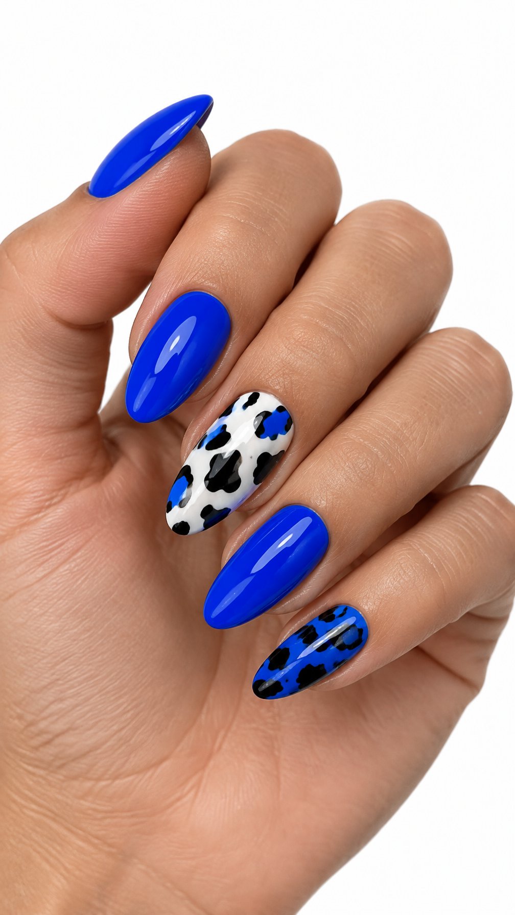 A single hand with glossy electric blue nails and black-and-white cow-print accent nails on a white background.