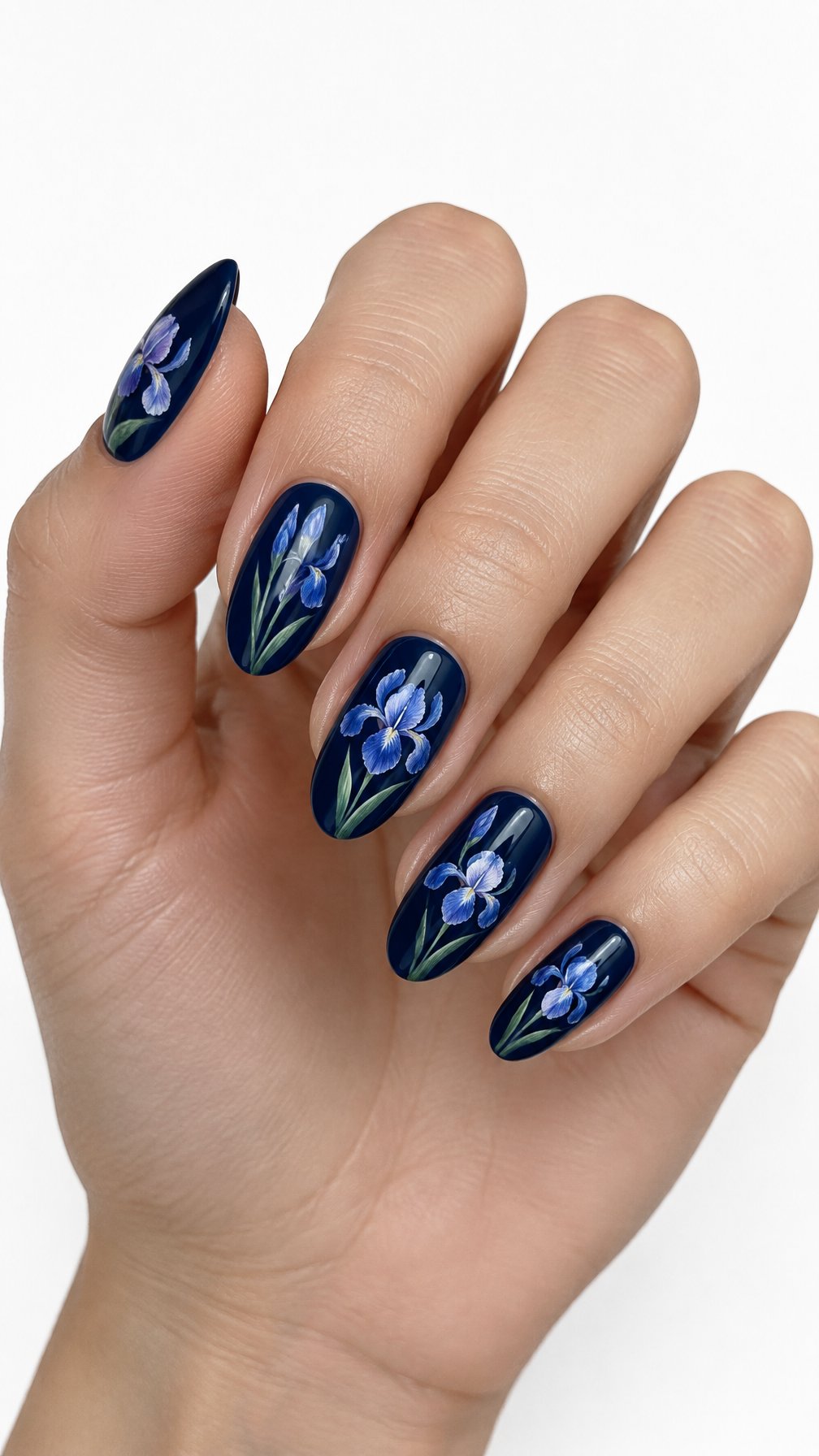 A single hand with glossy midnight-blue nails decorated with delicate blue and lavender iris flowers against a white background.