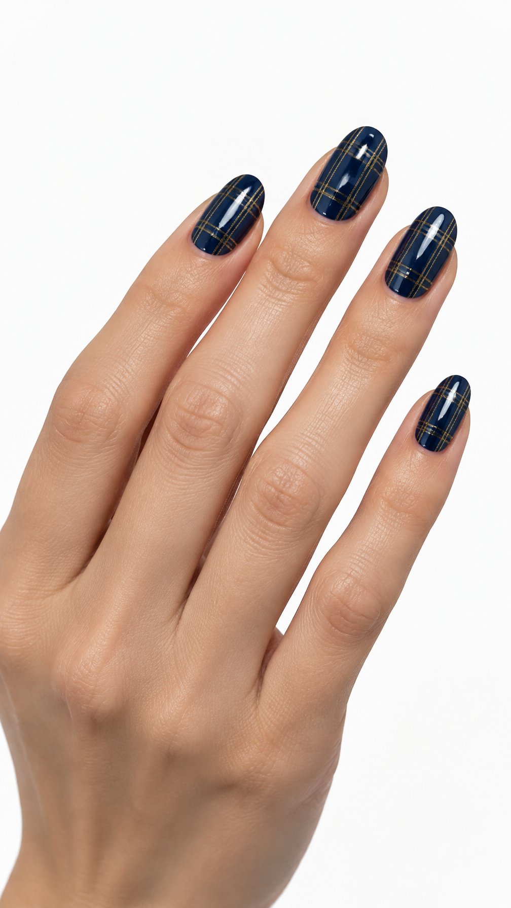 A single hand with glossy midnight blue plaid nails accented by fine gold lines against a white background.