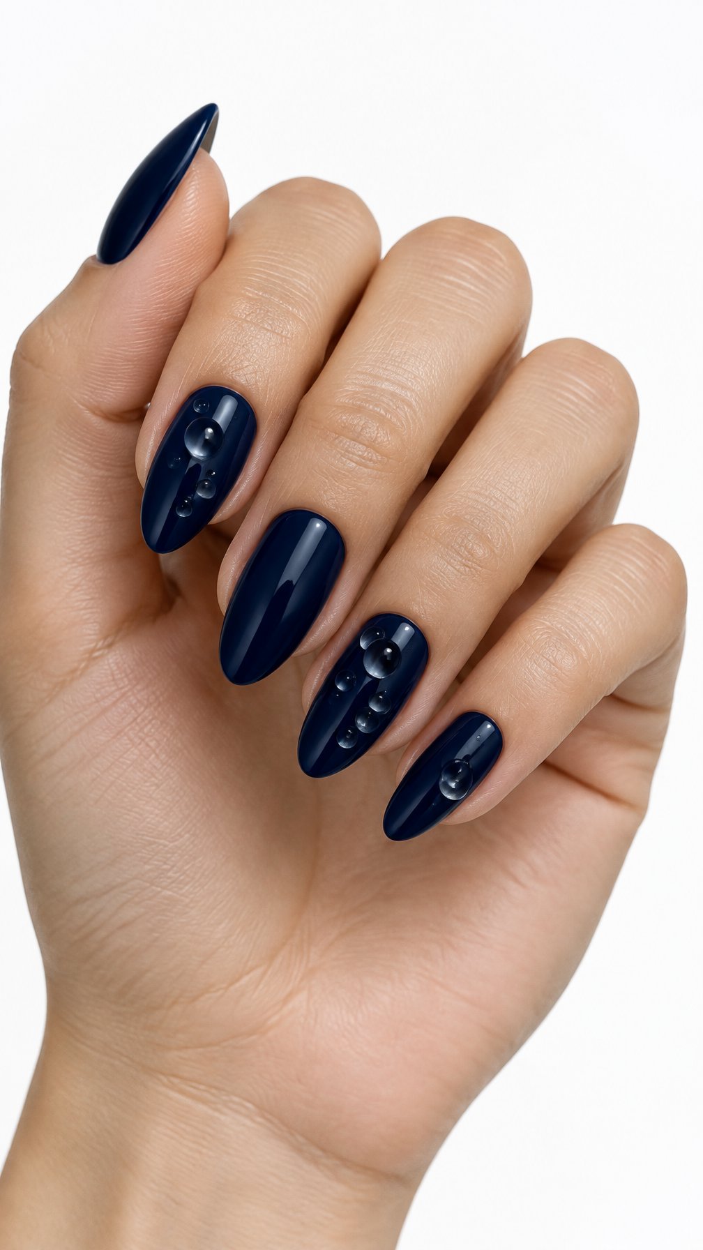 A single hand with glossy midnight blue nails decorated with clear three-dimensional raindrop details against a white background.