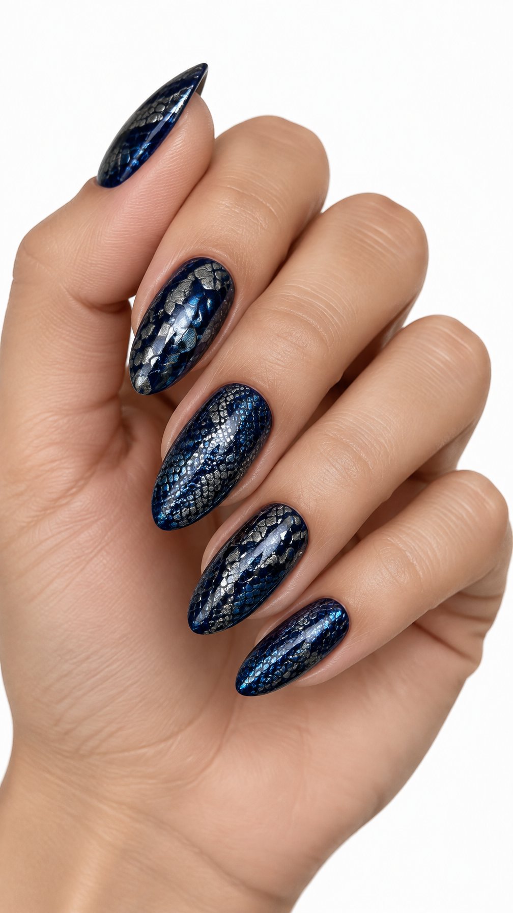A single hand with midnight blue nails decorated with metallic snake-scale patterns against a white background.