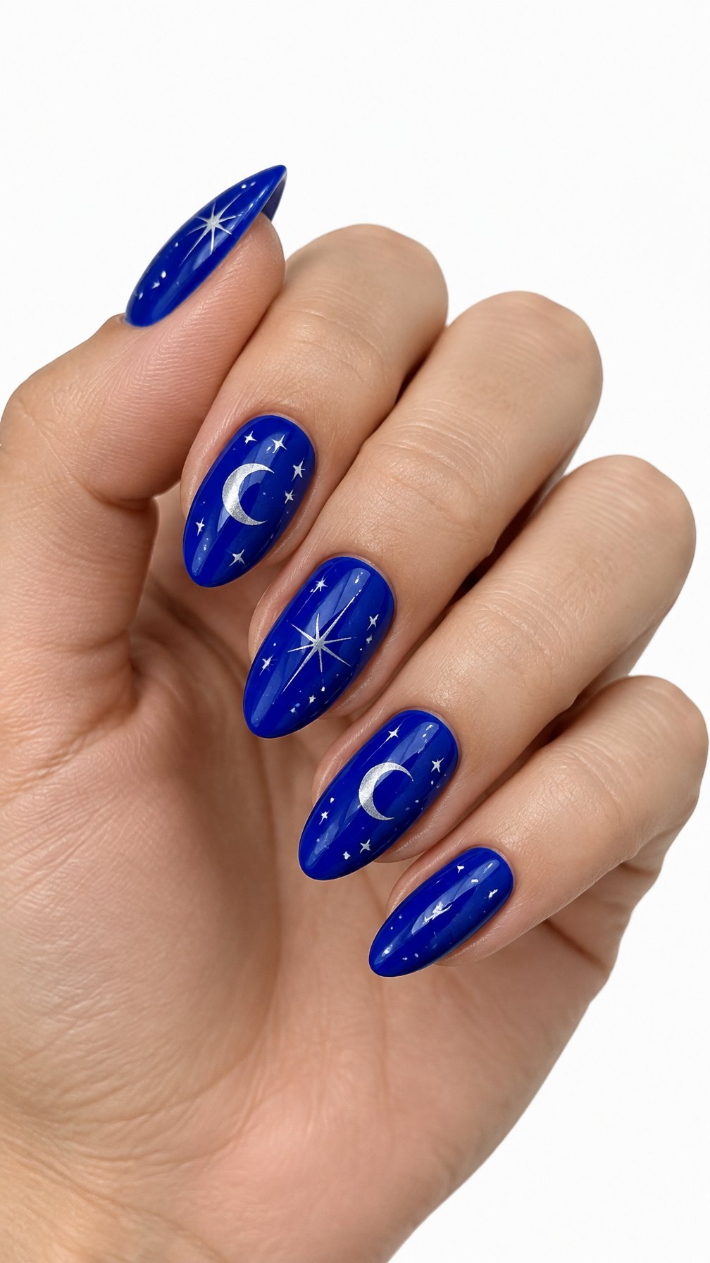 A single hand with glossy cobalt blue nails decorated with crescent moons and stars against a white background.