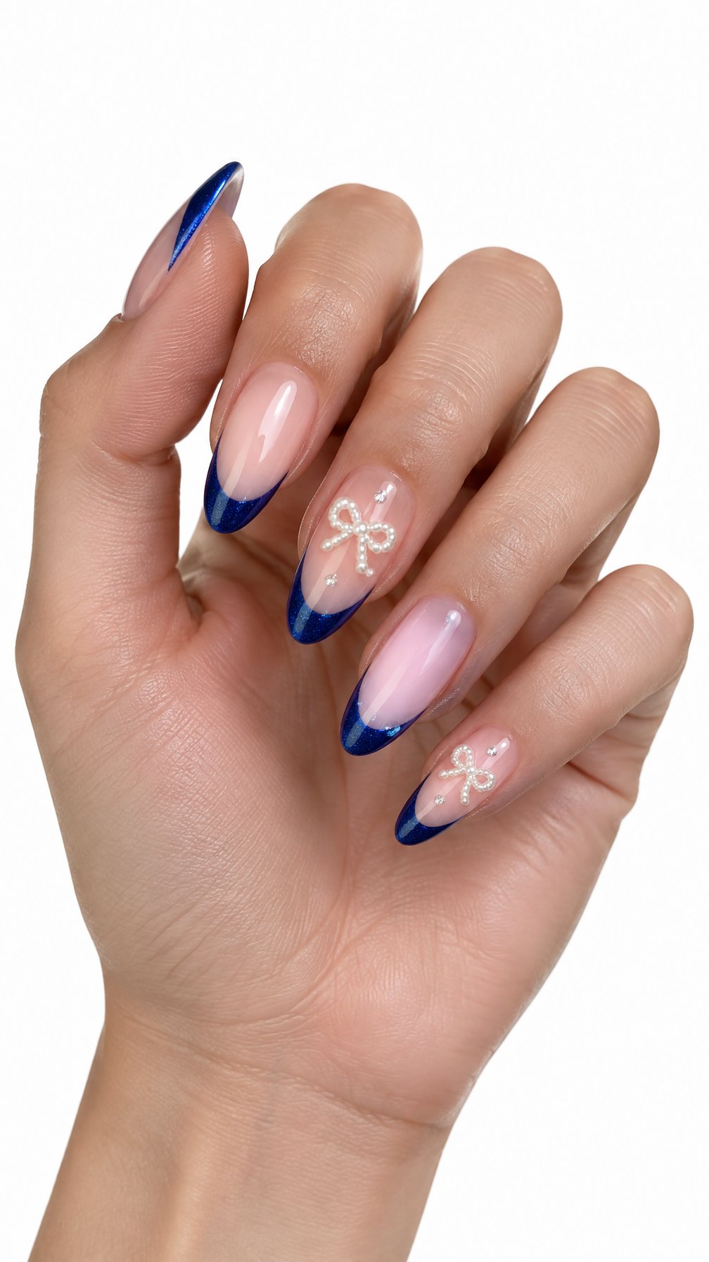 A single hand displays glossy blue French-tip nails decorated with small pearl bows against a white background.