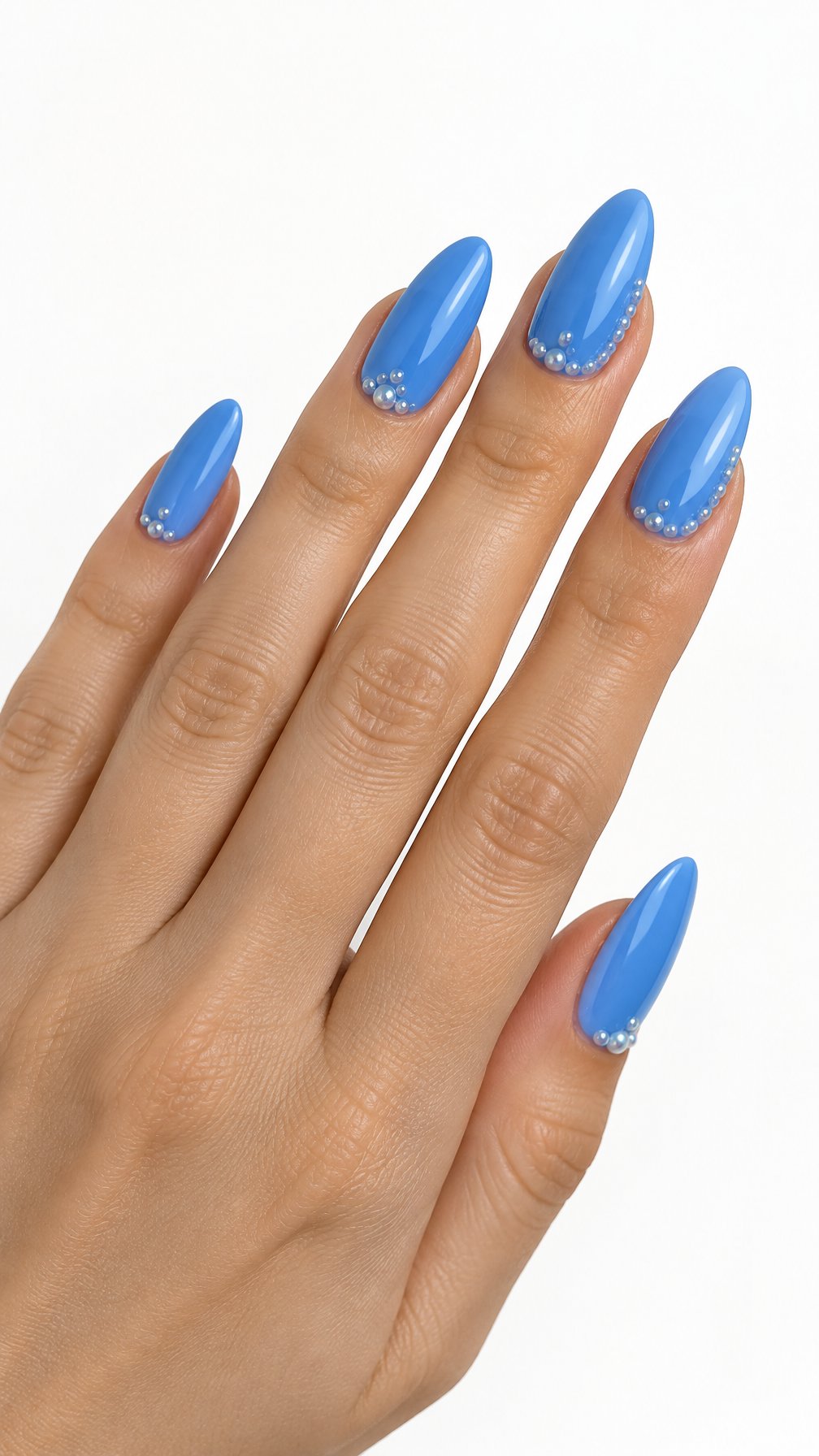 One hand with glossy azure blue almond-shaped nails decorated with tiny pearl clusters against a white background.