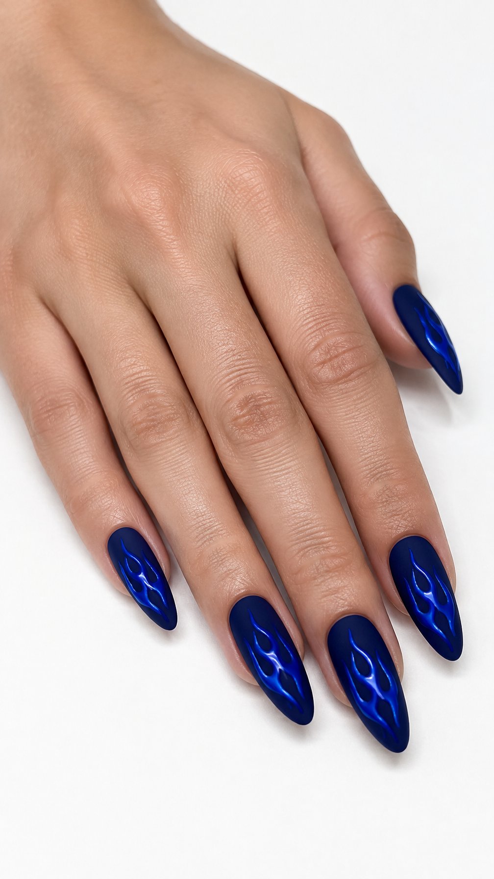 A single hand with matte navy blue nails decorated with glossy blue flame designs against a white background.