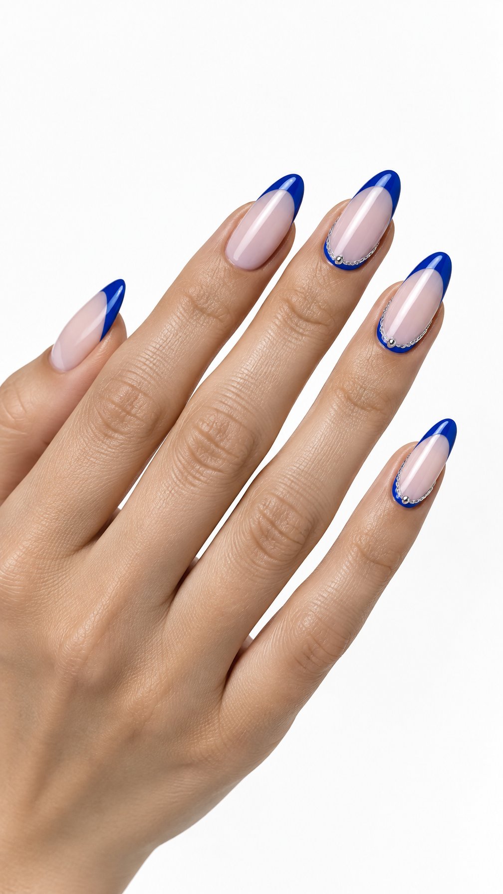 A single hand displays glossy blue French-tip nails with delicate silver chain accents against a white background.