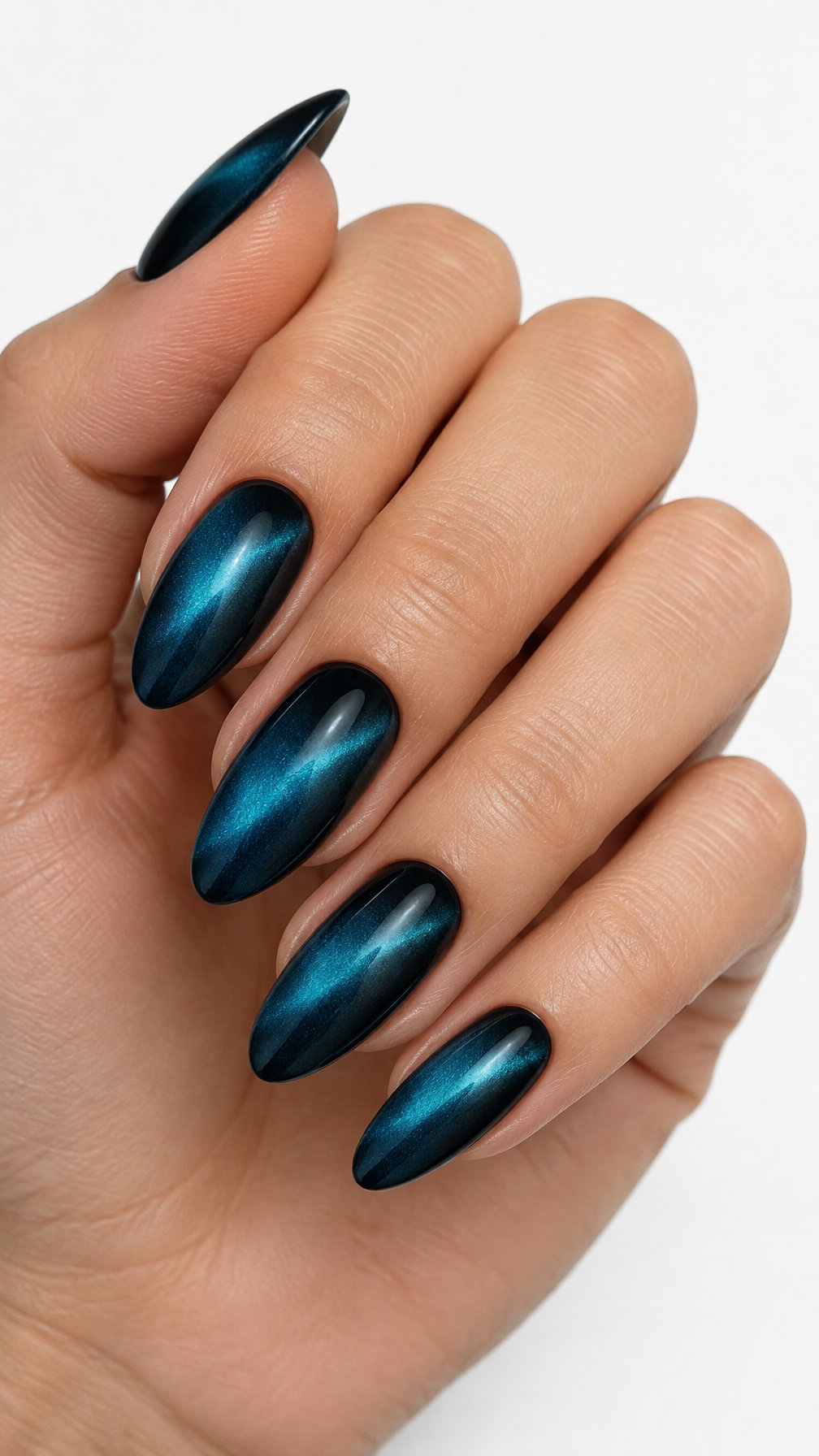 A single hand with teal-blue cat-eye nails featuring black velvet shading rests against a white background.