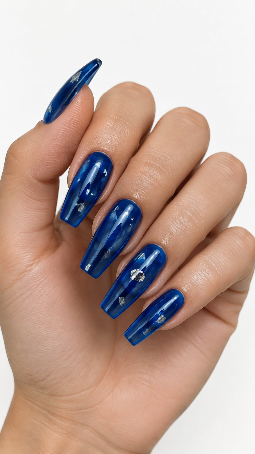 A single hand with glossy translucent blue nails decorated with small silver foil flakes against a white background.