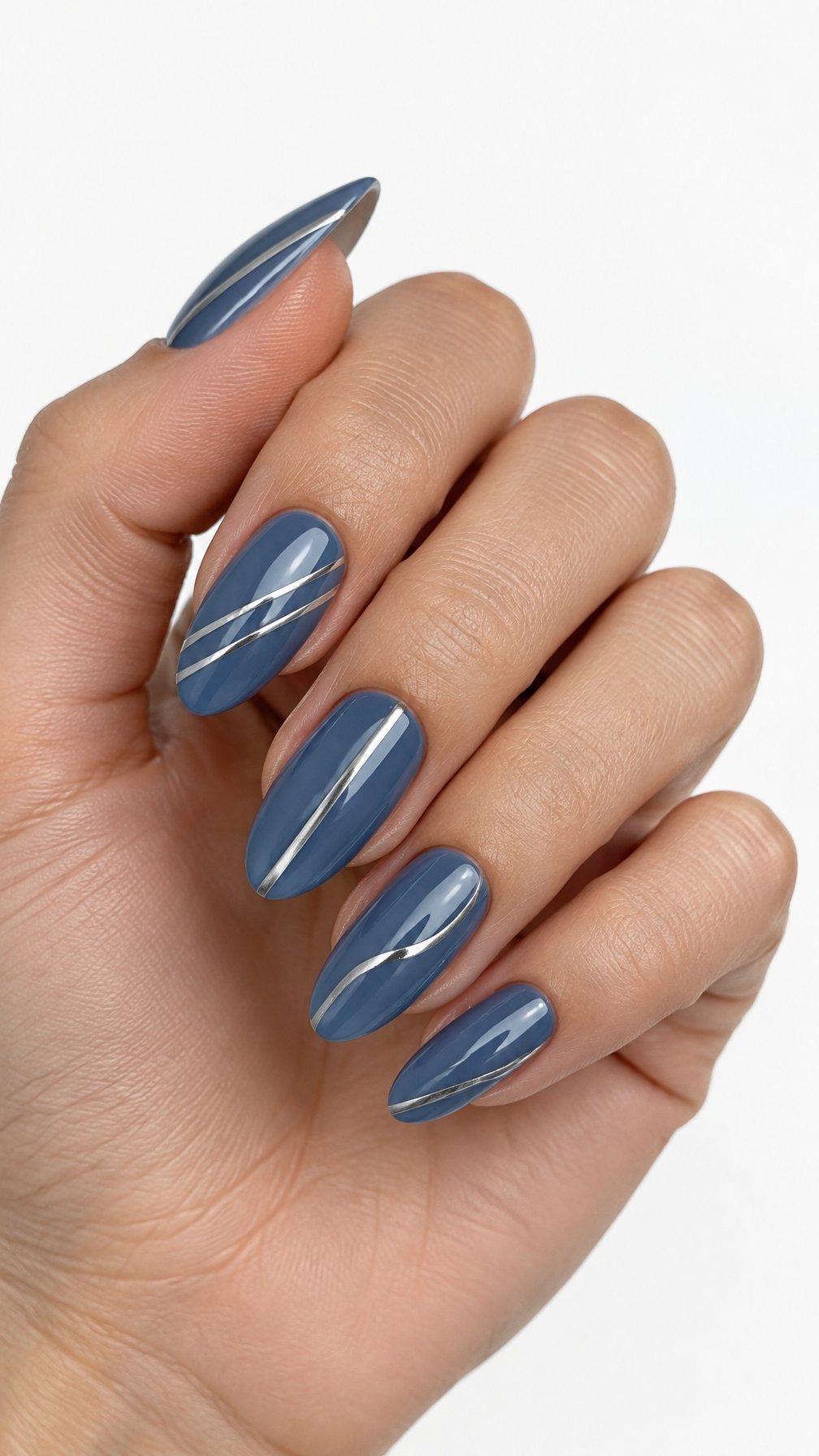 One hand with steel-blue manicured nails decorated with thin metallic silver stripes against a white background.
