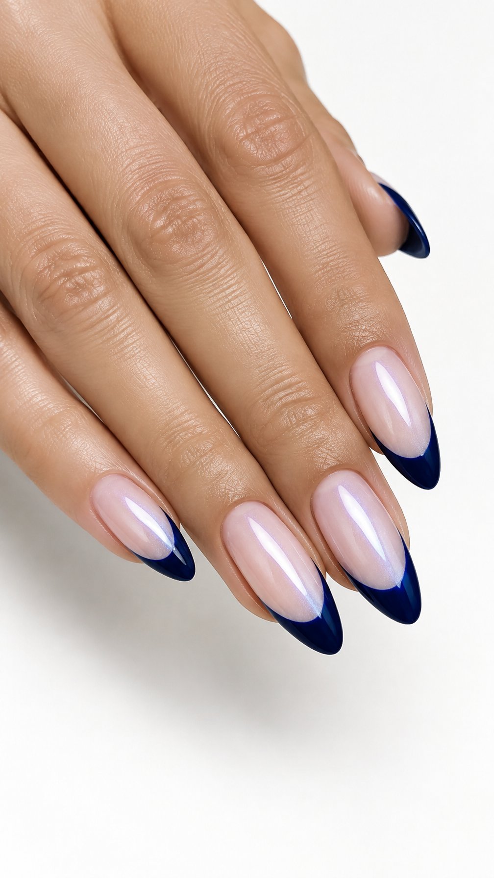 A single hand displays almond-shaped nails with midnight blue French tips and a pearly sheen against a white background.