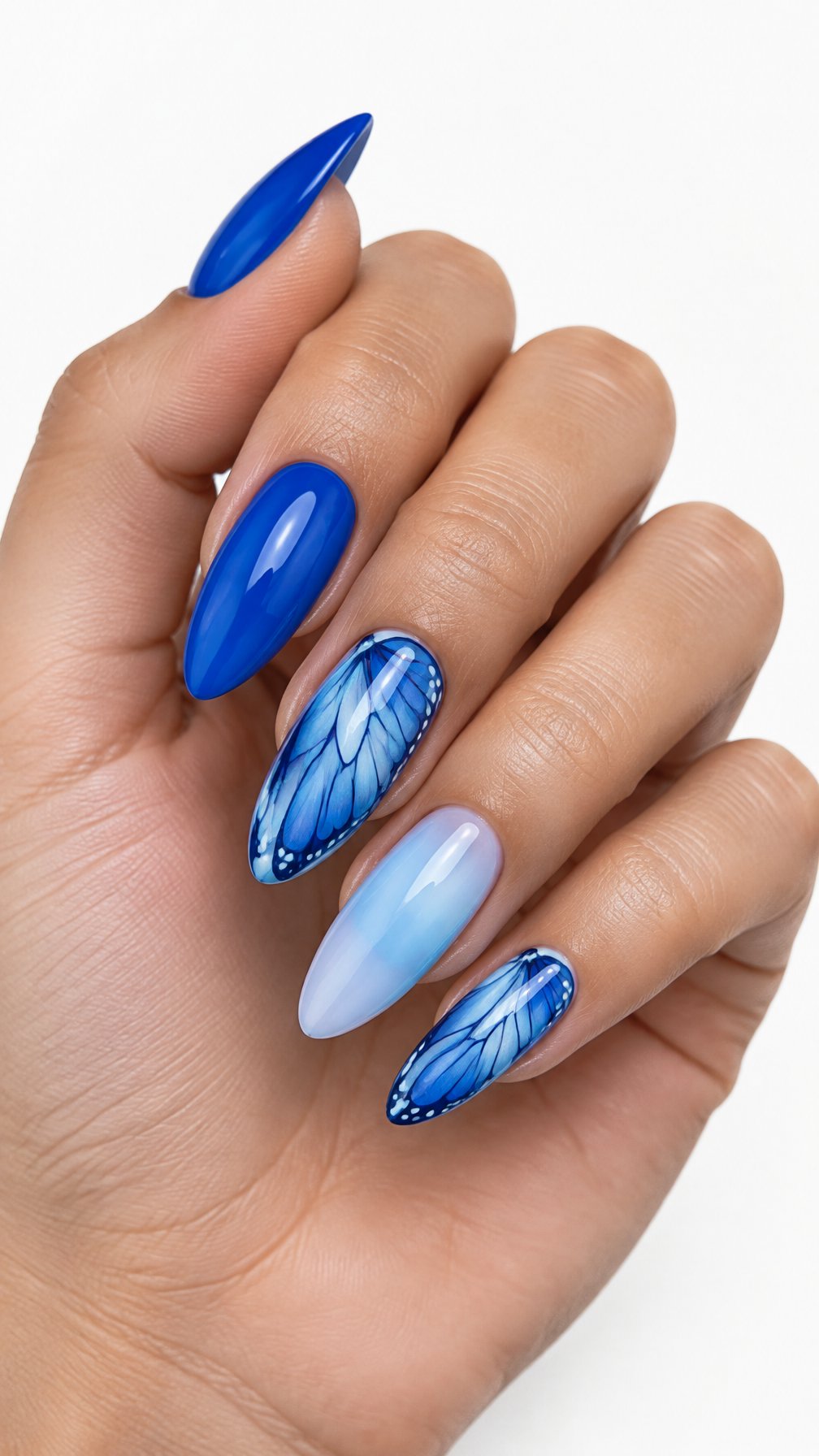 A single hand with long almond-shaped blue nails, including detailed butterfly-wing designs on the accent nails, photographed against a white background.