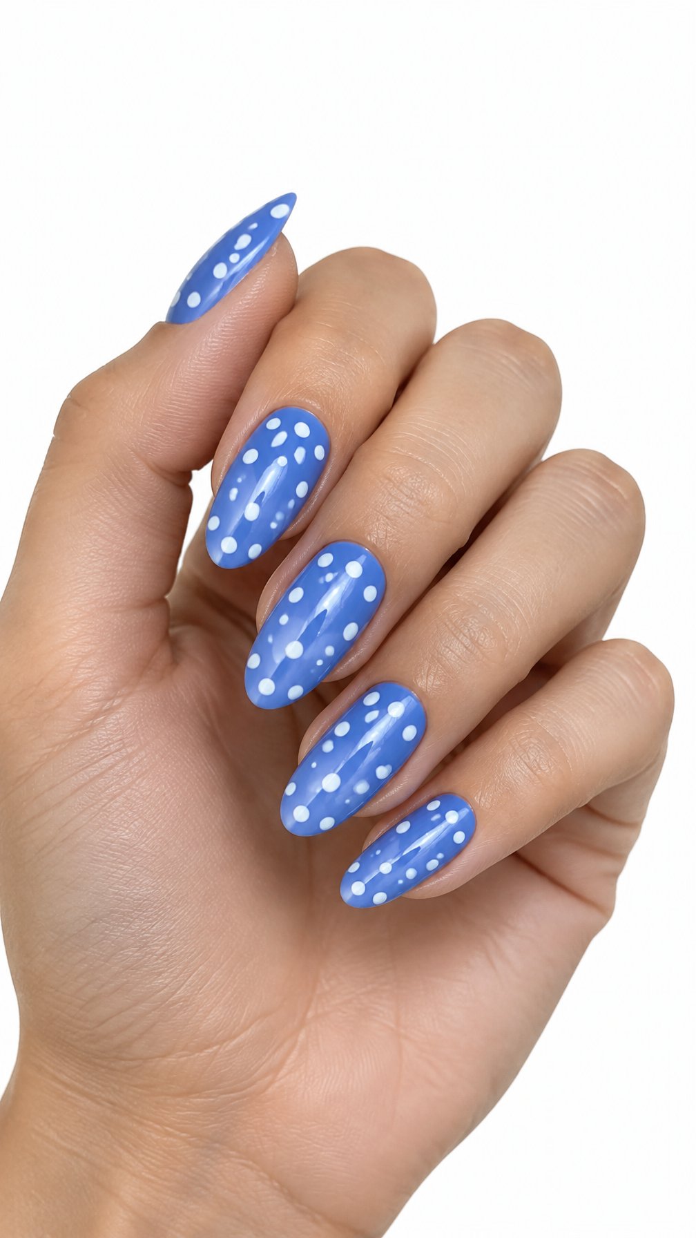 One hand with glossy cornflower blue almond-shaped nails decorated with white polka dots on a white background.