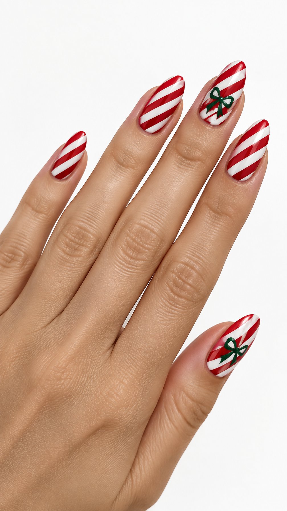 A single hand with glossy red-and-white candy-cane striped nails and small green bow designs on a white background.