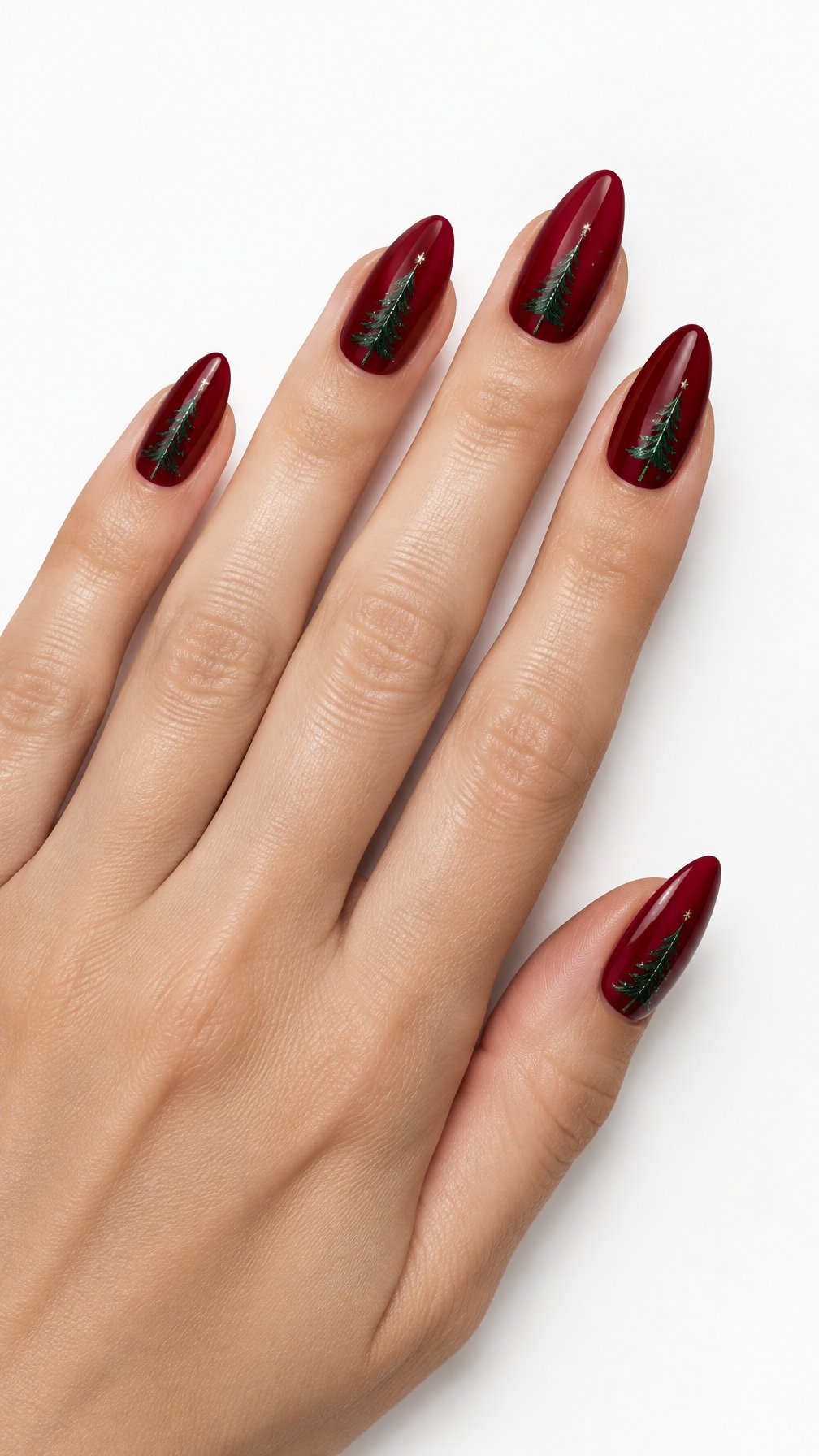 A single hand with glossy red nails decorated with green evergreen tree silhouettes against a white background.