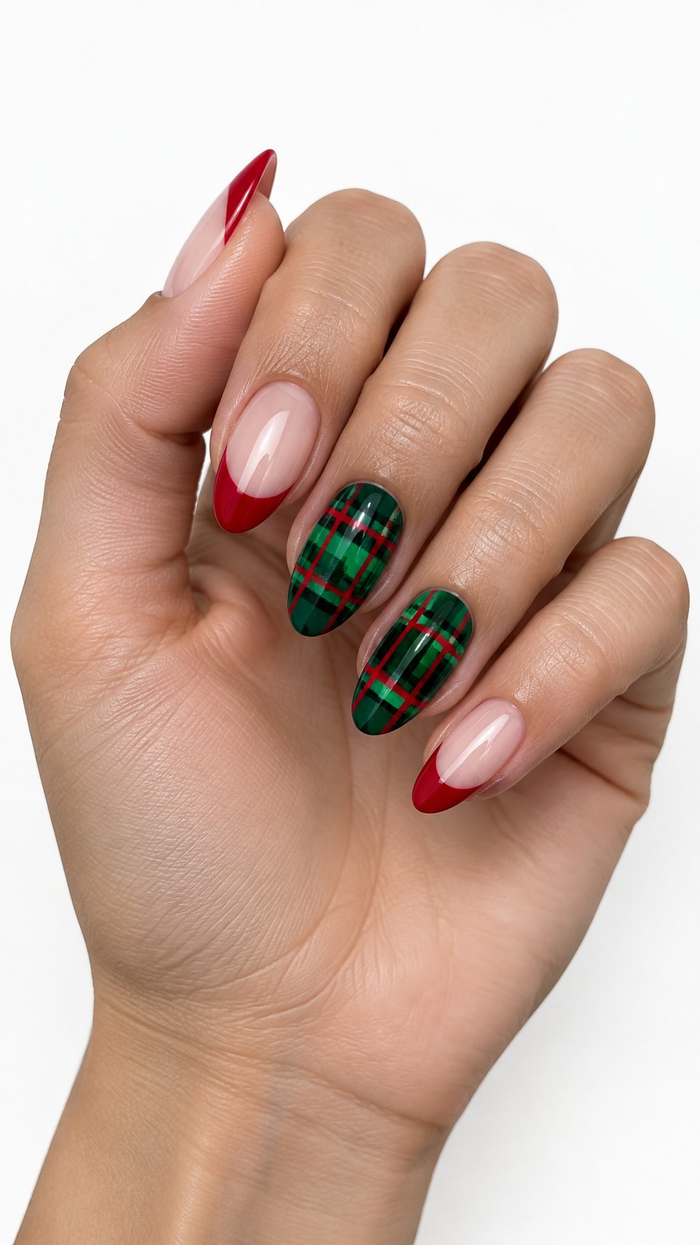 A single hand with glossy red French-tip nails and green tartan accent nails against a white background.