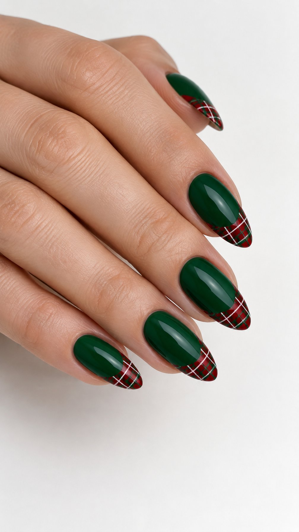 A single hand with glossy green nails and red plaid French tips against a white background.