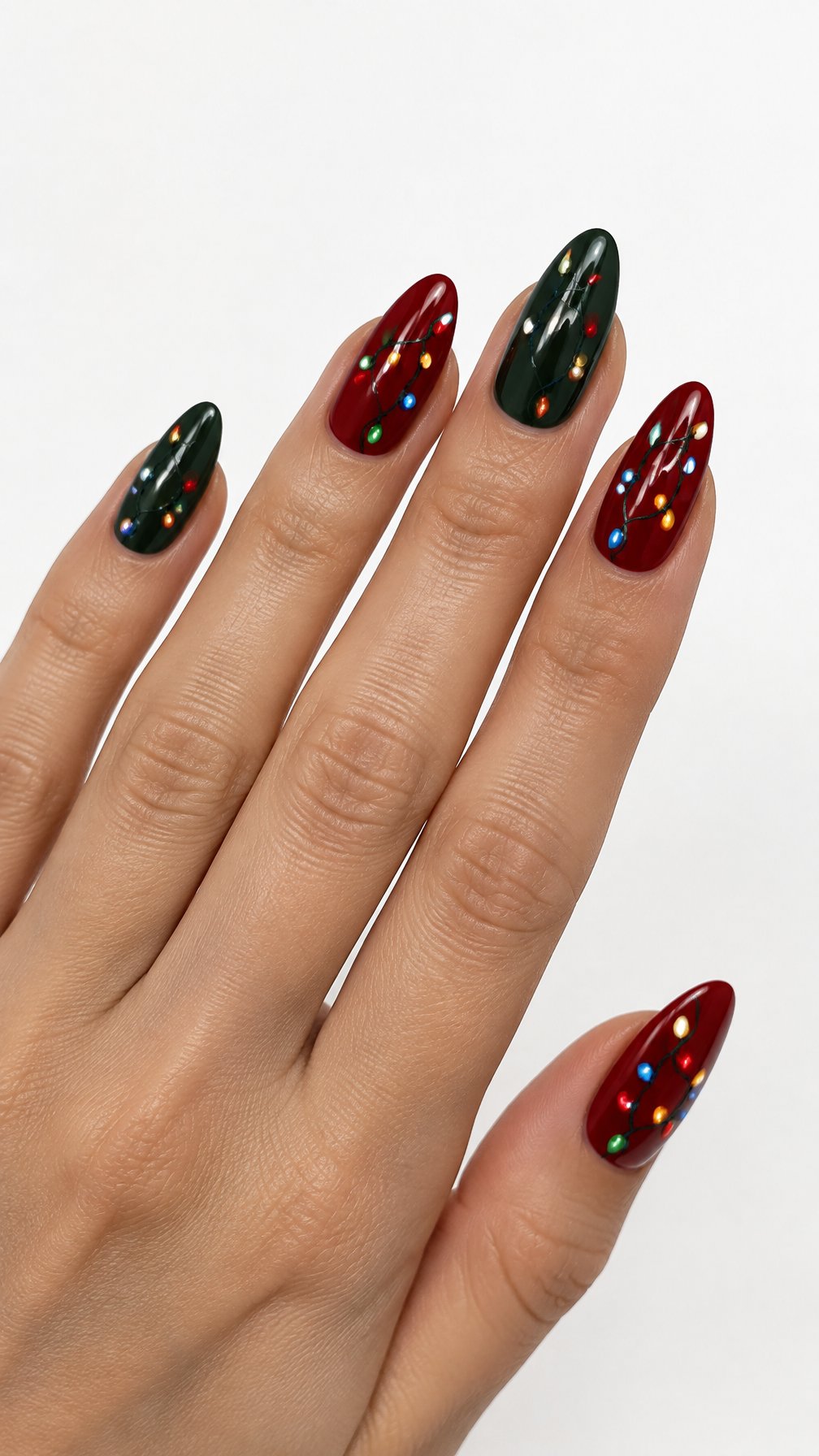 A single hand with red and green Christmas light string nail art against a white background.