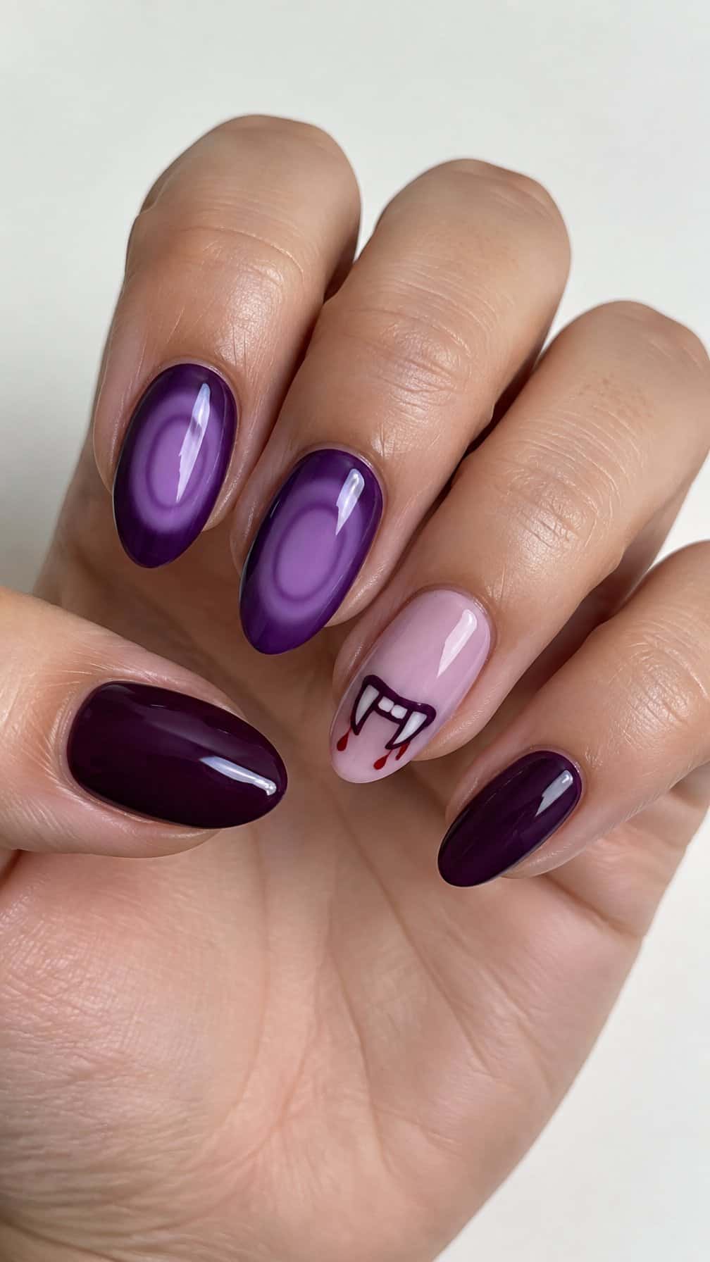 Glossy purple Halloween-themed gel manicure and simple vampire bite designs