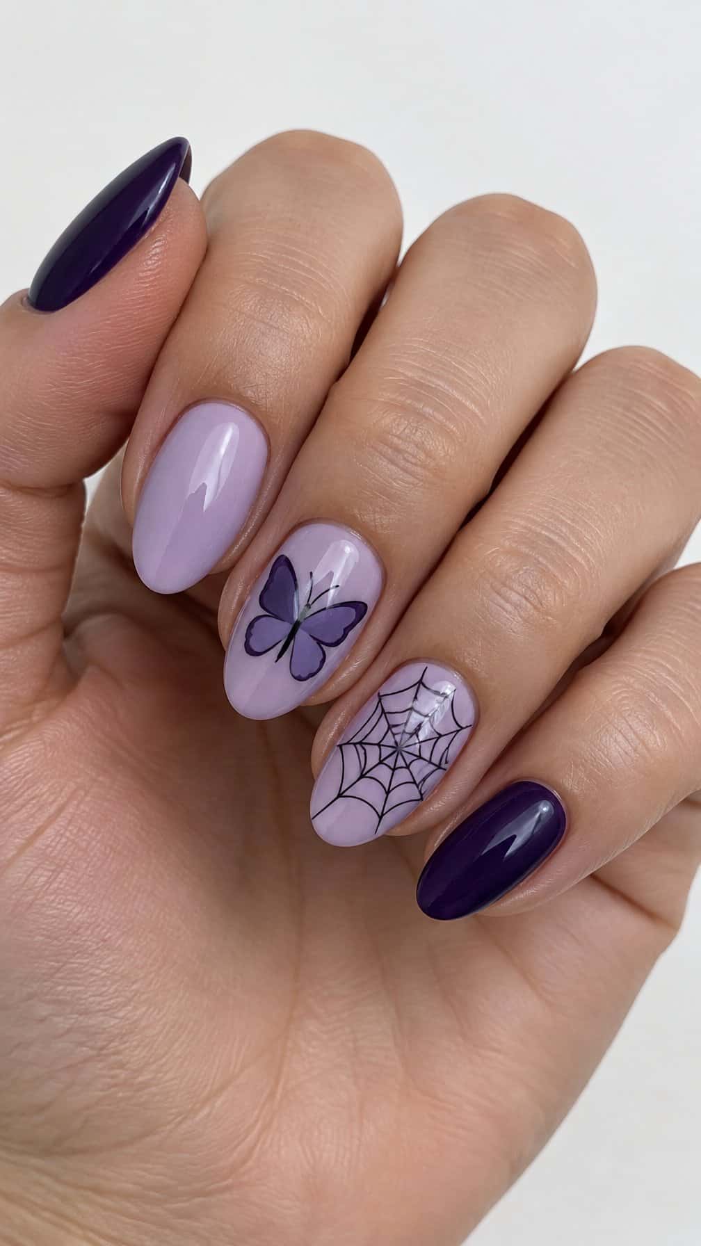 Glossy purple butterfly and spiderweb nail designs