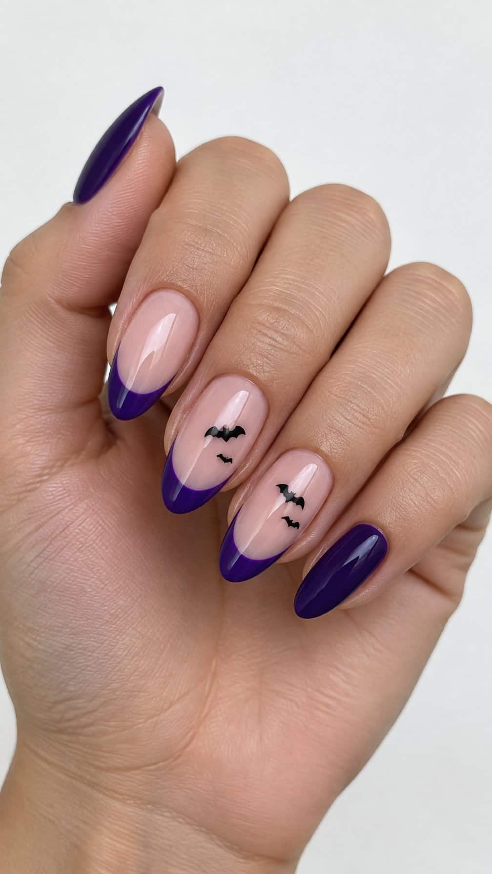 Glossy violet French-tip nails and tiny black bat designs